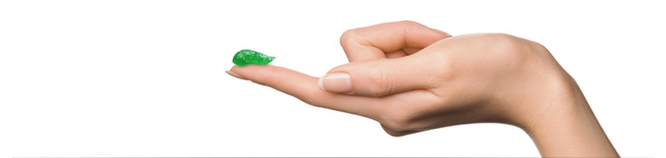 Frau streckt ihren Zeigefinger aus, auf dem ein grüner Streifen ilon Abszess-Salbe präsentiert wird